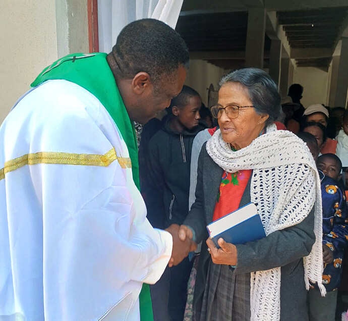 Le Révérend Éric Kalumba salue un membre de l'Église Méthodiste Unie d'Ambodifasika après le culte, à Ambodifasika, Madagascar. Le révérend Kalumba, missionnaire du United Methodist Board of Global Ministries (Conseil Méthodiste Uni des Ministères Mondiaux), est chargé d'implanter de nouvelles Églises Méthodistes Unies dans toute l'île. Photo par Esdras Rakotoarivony, UM News.
