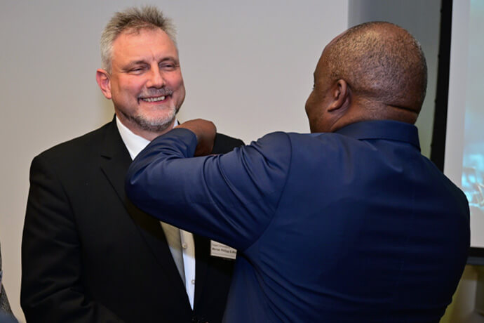 O bispo Mande Muyombo coloca o broche do bispo na lapela do Rev. Werner Philipp depois que ele foi eleito bispo metodista unido na Conferência Central da Alemanha em 13 de fevereiro em Würzburg, Alemanha. Foto de Klaus Ulrich Ruof, EmK Public Relations.
