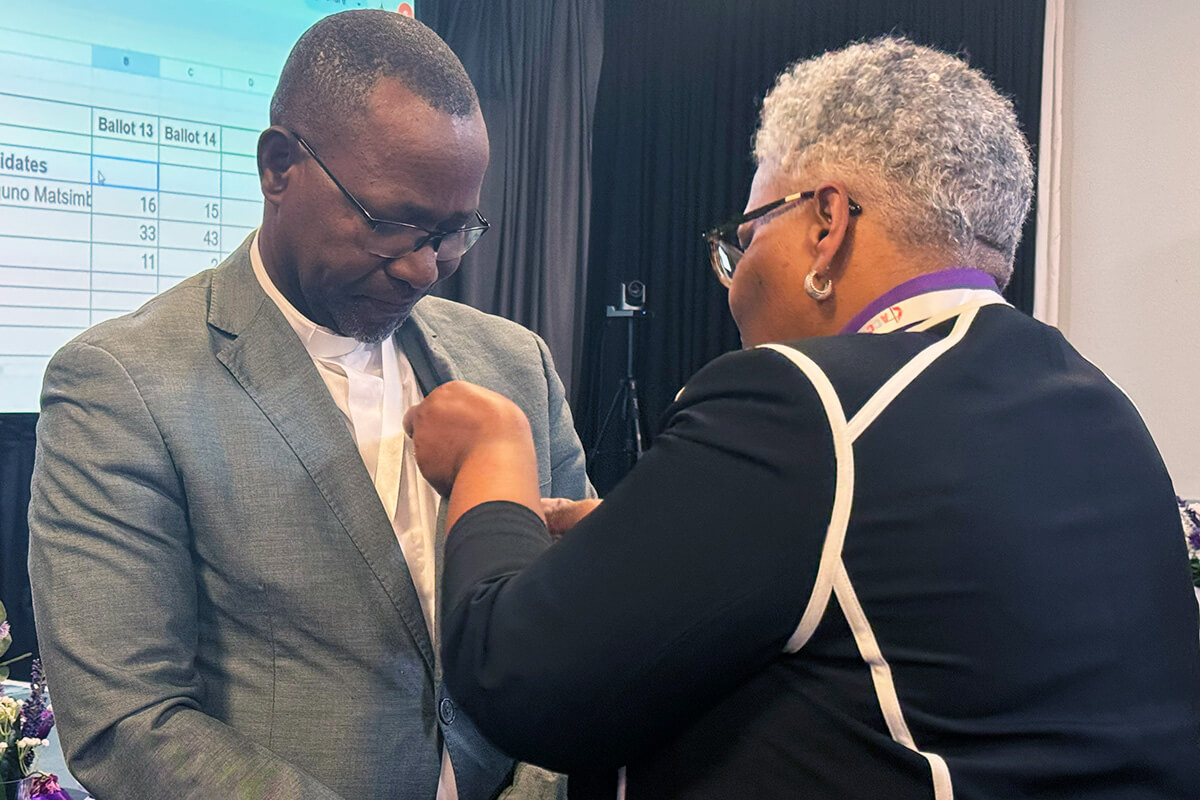 Le révérend João Filimone Sambo, du Mozambique, reçoit l'épingle épiscopale Méthodiste Unie des mains de l'évêque LaTrelle Easterling. Mgr. Sambo a été élu évêque le 15 mars par la Conférence Centrale d'Afrique. Photo par Priscilla Muzerengwa, United Methodist Communications.