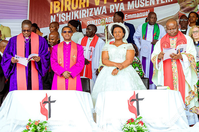 Bishop Daniel Wandabula (from left), newly elected Bishop Emmanuel Sinzohagera and his wife, Uwimana Delphine Sinzohagera, and Bishop Mande Muyombo stand on stage during Sinzohagera’s installation as a United Methodist bishop in Gitega, Burundi, on March 29. Sinzohagera, an Africa University graduate, was the first bishop elected at the Africa Central Conference on March 15. Photo by Priscilla Muzerengwa, United Methodist Communications.
