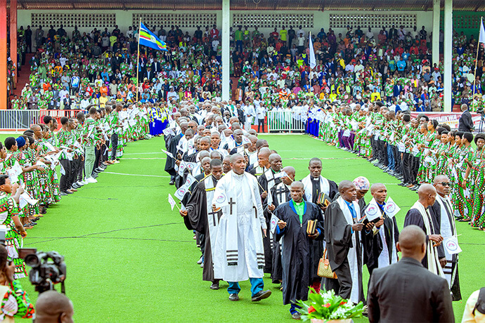 United Methodist pastors file in procession at the start of the celebrations for the new Burundi-Rwanda Episcopal Area and installation of Bishop Emmanuel Sinzohagera at Ingoma Stadium in Gitega, Burundi. The pastors were flanked by several United Methodist church choirs in their branded uniforms. Photo by Priscilla Muzerengwa, United Methodist Communications.