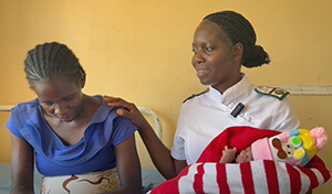 Une infirmière du refuge pour mères de la clinique rurale Chikwizo de l'Église Méthodiste Unie au Zimbabwe tient un nouveau-né dans ses bras. Image vidéo d'Eveline Chikwanah, UM News.