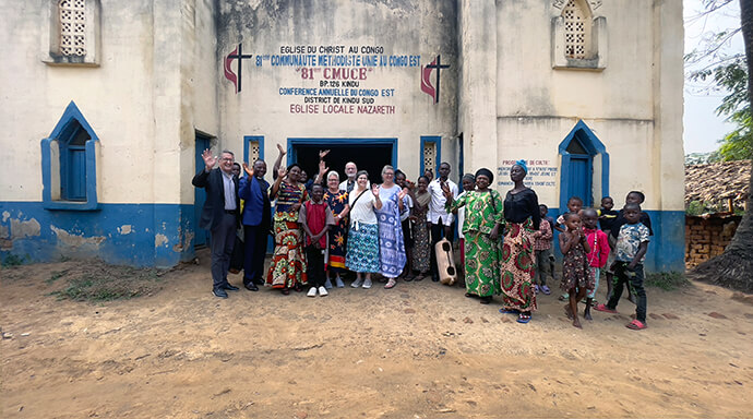 Les membres d'une délégation méthodiste unie des États-Unis posent avec des responsables laïcs et des membres du clergé de l'est du Congo devant l'église méthodiste unie locale de Nazareth à Kindu. Pendant leur séjour dans l'est du Congo, la délégation a visité des églises locales dans les districts nord et sud et a participé à des sessions de prière et à des discussions sur l'évangélisation. Photo de Chadrack Tambwe Londe, UM News.
