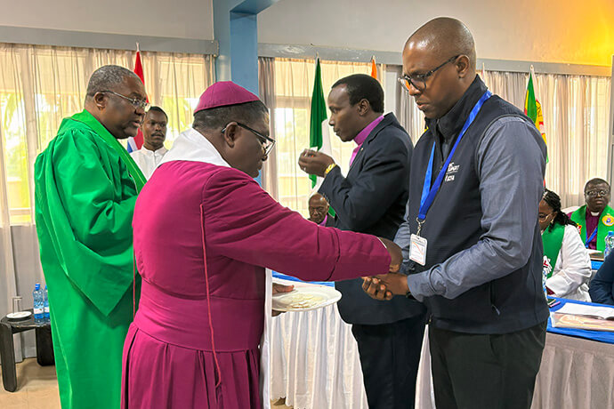 Mgr Paul Kwabena Boafo, Président du Conseil Méthodiste Africain, sert des éléments de communion à Ndzulo Tueche, membre du personnel du Conseil Général des Finances et de l'Administration de l'Église Méthodiste Unie, lors du sommet des Chefs de Conférence Africains qui s'est tenu du 14 au 19 mai à Nairobi, au Kenya. La réunion visait à créer un espace pour les Evêques Wesleyens afin de tracer la voie à suivre pour le mouvement Méthodiste en Afrique. Photo par Eveline Chikwanah, UM News.