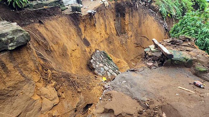 Une profonde crevasse causée par les pluies torrentielles illustre la violence de l'érosion qui a englouti plusieurs maisons dans la commune de Ngaliema, exacerbant la vulnérabilité des quartiers précaires aux inondations à Kinshasa. La crevasse a été creusée par les eaux de pluie dans la nuit du 14 juin 2025. Photo par le Révérend Fiston Okito, UM News.