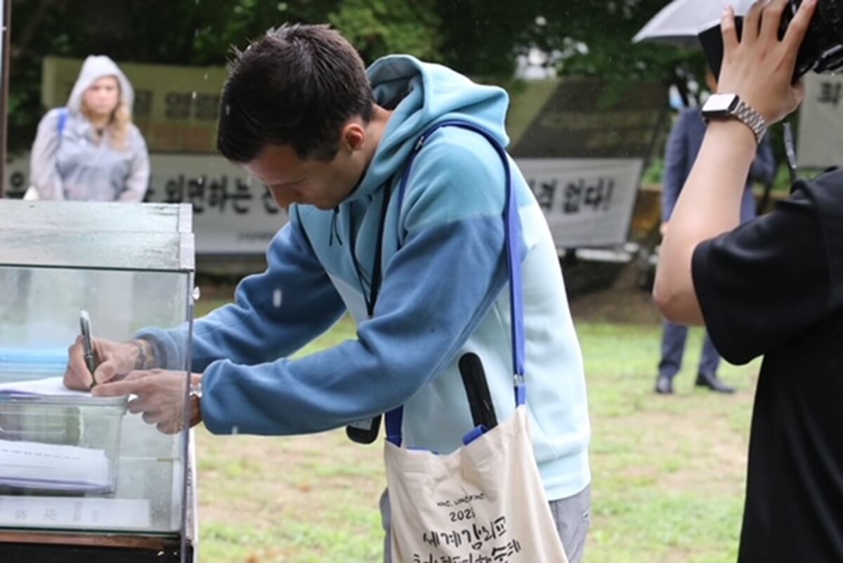 2025년 6월 25일, 노르웨이에서 참가한 스페인 시네스(Svein Sinnes)가 세계에서 가장 긴 무덤인 골령골 평화공원에서 기도를 쓰고 있다. 사진, 김응선 목사, 연합감리교뉴스.