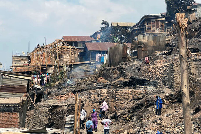 Kashalile Bony (avec chemise bleu), fidèle Méthodiste Uni de l’Église Locale Bethléem de Kadutu, fouille les décombres de sa maison incendiée à l’aide d’une bêche sur l’avenue Kaduru à Bukavu. Une centaine de familles Méthodistes Unies font partie de près de 1500 familles qui ont perdu leurs maisons dans un incendie dévastateur survenu dans la nuit du 17 juillet 2025 à Nyakaliba, un quartier densément peuplé de Bukavu dans l’Est de la République démocratique du Congo. Photo avec l’aimable autorisation du District Ecclésiastique de Bukavu.
