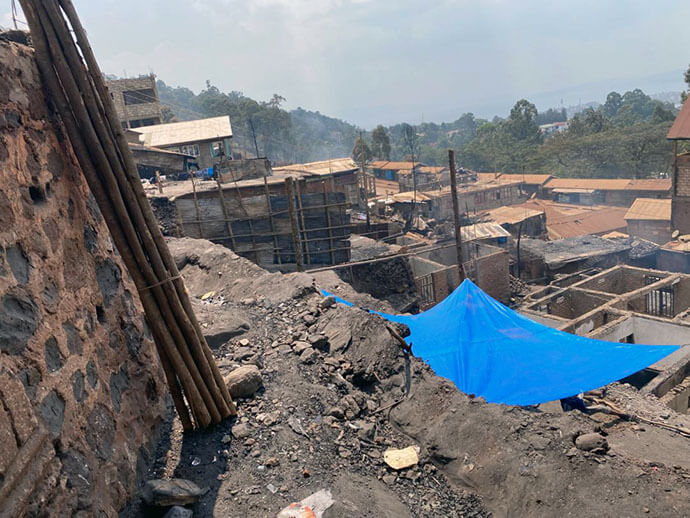 Des maisons détruites sur une colline de Nyakaliba, où des bâches bleues servent d’abris de fortune au milieu des décombres. Des centaines de familles dorment à la belle étoile dans des conditions précaires, notamment des femmes enceintes, des enfants en bas âge, des personnes âgées et des personnes à mobilité réduite, exposées à des risques sanitaires et psychologiques accrus après avoir tout perdu dans l’incendie. Photo avec l’aimable autorisation du District Ecclésiastique de Bukavu.