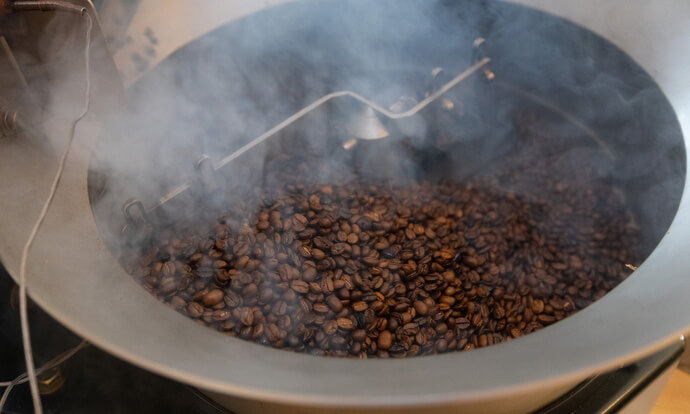 Smoke rises from freshly roasted coffee beans at Deep Time. 