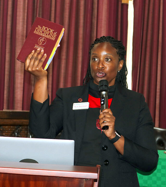 A Revda. Aleze M. Fulbright, secretária da Conferência Geral, segura o Livro de Disciplina 2020/2024 durante um debate com secretários das conferências anuais no treinamento da CGFA na Universidade de África. O grupo falou sobre a importância de compilar e compartilhar actas com informações precisas sobre os membros. Foto de Eveline Chikwanah, Notícias da UM.