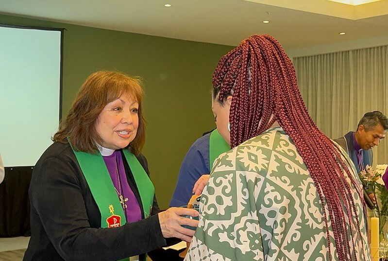 La Revda. Minerva Carcaño, obispa retirada de La Iglesia Metodista Unida y líder de la Estrategia Holística en América Latina y el Caribe ministra la comunión durante el culto de apertura de la consulta. Foto Rev. Gustavo Vasquez, Noticias MU.