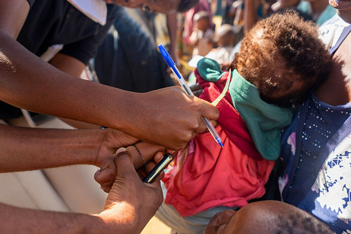 Nutrition program officers measure a baby’s mid-upper arm circumference to screen for pediatric malnutrition at Dzaleka Refugee Camp in Dowa District, Malawi. The screening is part of a United Methodist Church program at the camp that offers health and nutrition services. Photo by Francis Nkhoma, UM News. 
