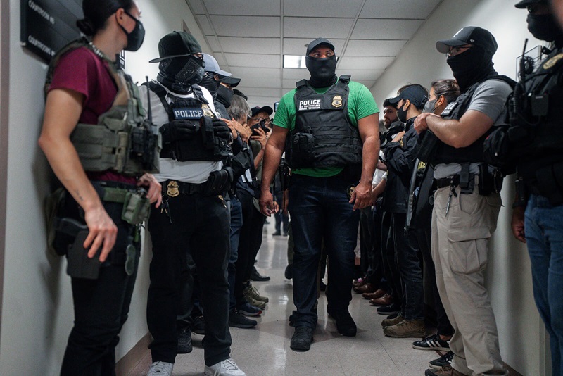 Agentes federales enmascarados esperan afuera de una sala de audiencias de inmigración el 8 de julio de 2025 en Nueva York. Foto cortesía de Olga Fedorova, AP.