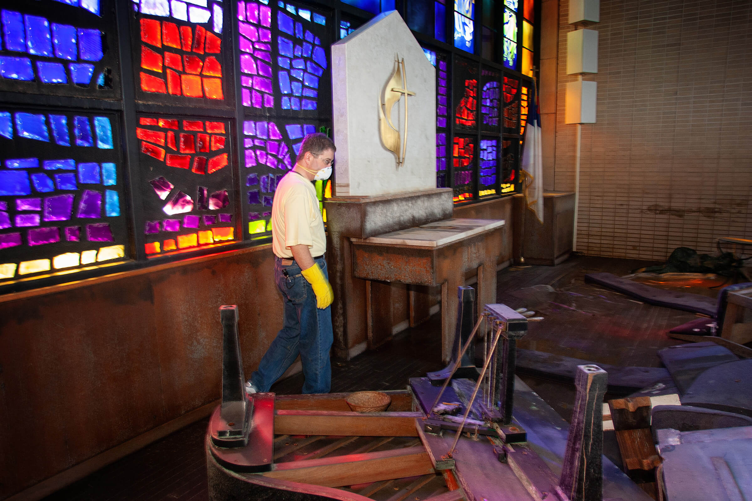 The Rev. Darryl Tate views the ruined sanctuary of St. Luke’s United Methodist Church in New Orleans for the first time since he fled Hurricane Katrina in August 2005. An overturned grand piano rests in the foreground. Photo by Mike DuBose, UM News.