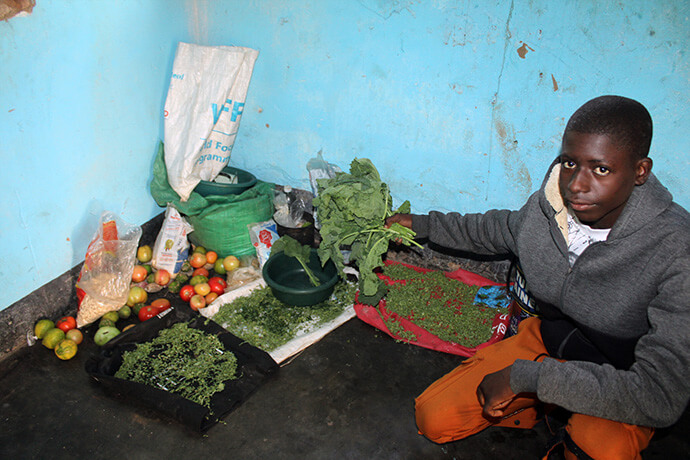 Newton Hunduza, a boarding student at Dindi Mission, shows off the facility’s pantry where vegetables and grocery items are stored. Photo by Kudzai Chingwe, UM News.