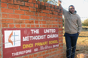 Pastor Christopher Ngoni Muponda stands at the Dindi Primary School gate. A new boarding facility at the mission is supported by church members, educators, parents and local leaders Photo by Kudzai Chingwe, UM News.